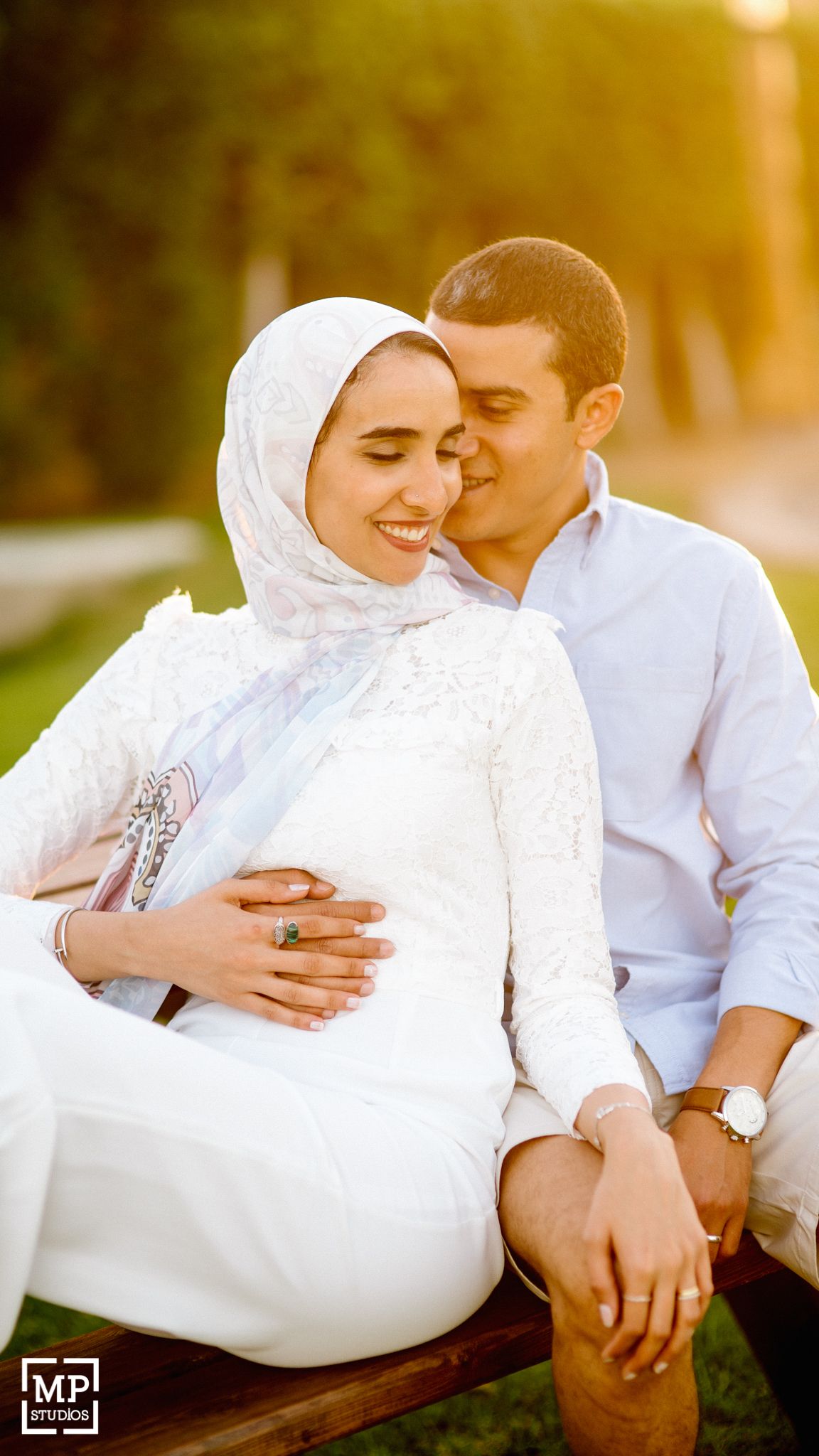 Intimate sunset portrait of couple in white attire sharing tender moment outdoors.