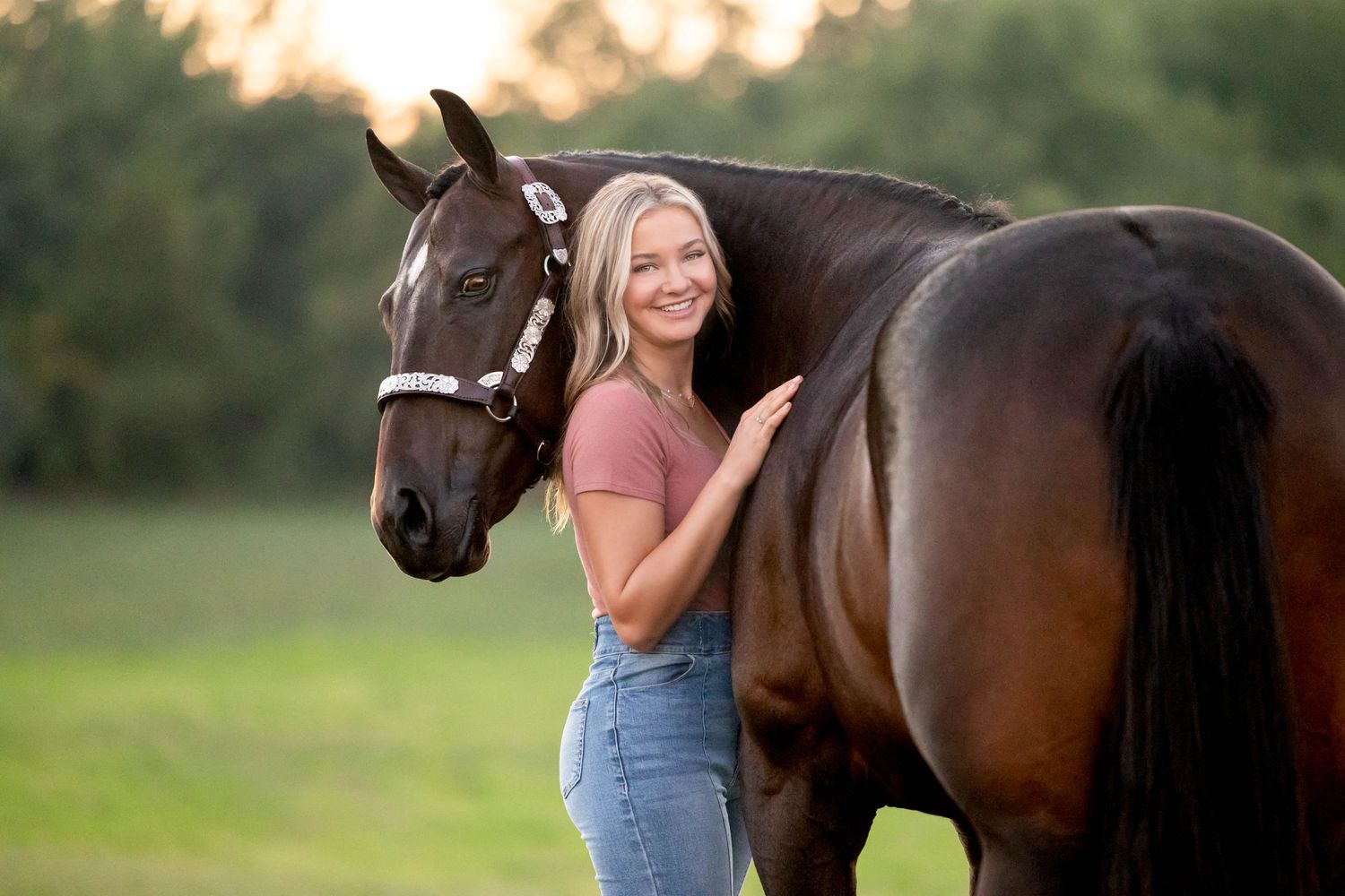 Girl in red top standing with her bay mare in a western show halter