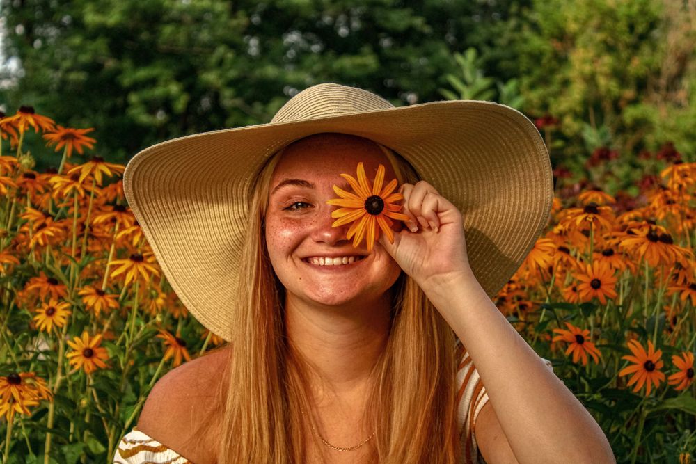 Collection of portraits in a sunny flower garden with orange blooms and straw hats.