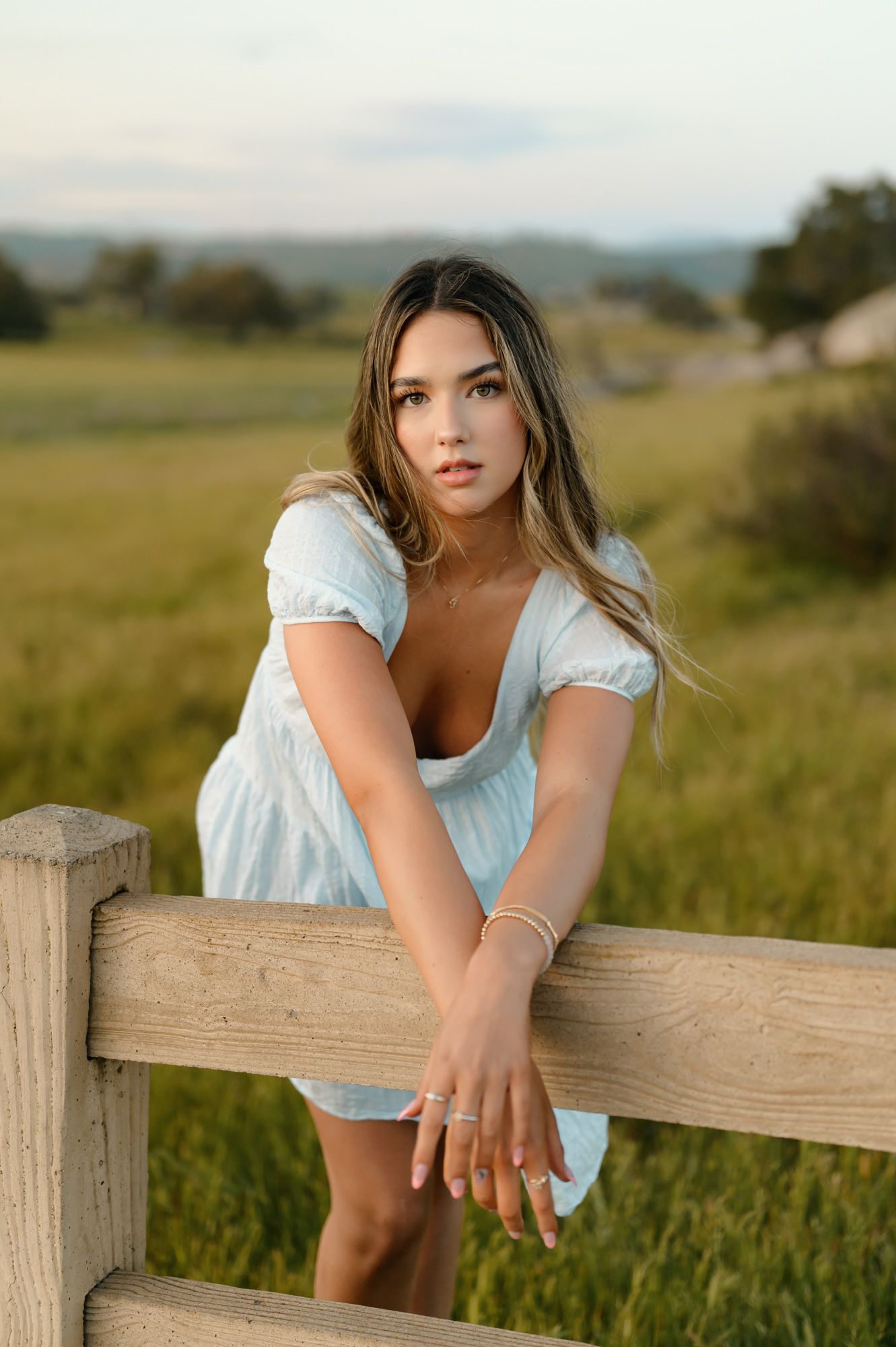 Santa Barbara Senior pictures by Thousand Oaks photographer of girl standing in grassy field leaning on fence
