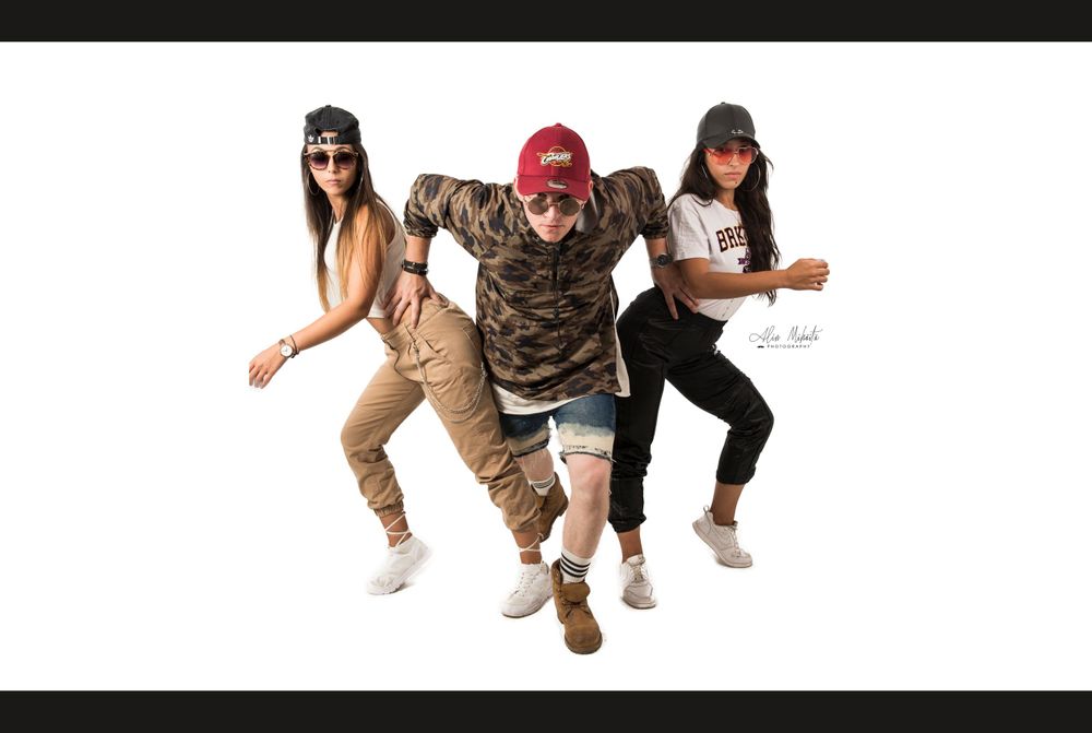 Dance group performs synchronized hip hop moves in urban style clothing.