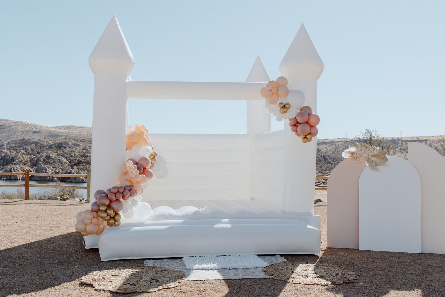 White geometric wedding decor elements arranged against a desert landscape with mountains in the background.