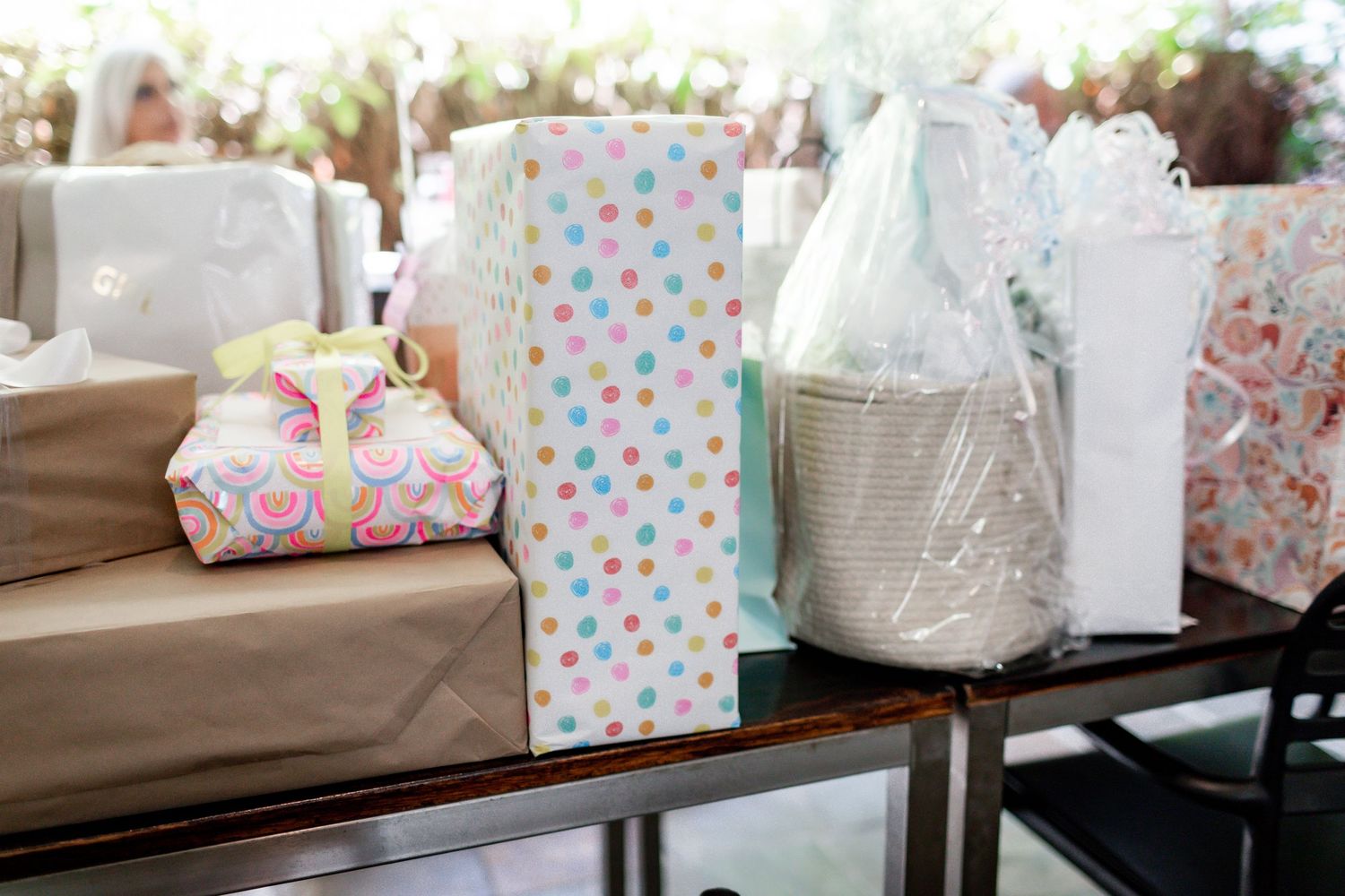 Baby shower gifts wrapped in polka dot paper and white tissue on display at a party.