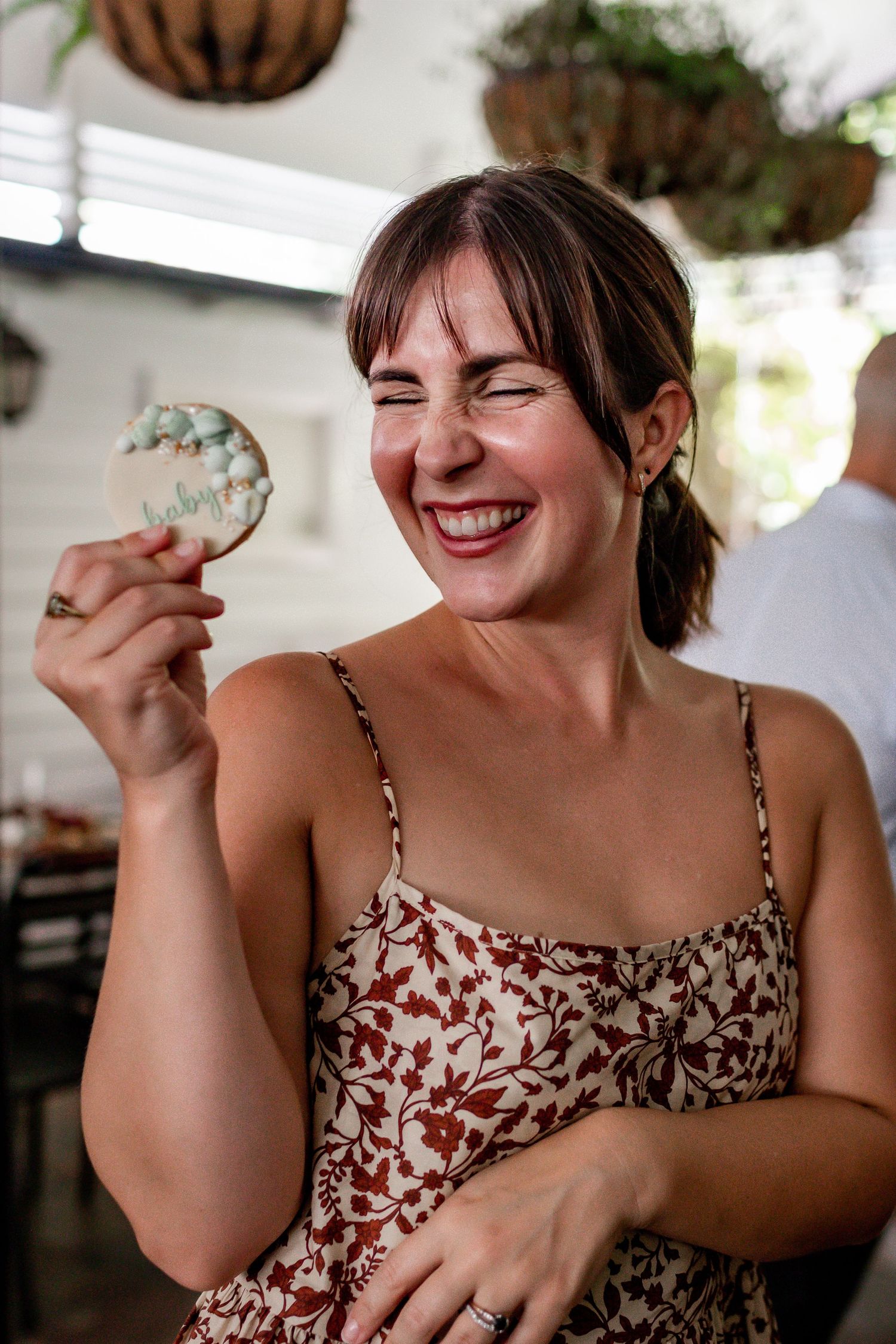 A guest enjoying a decorated cookie with a joyful expression at a celebration.