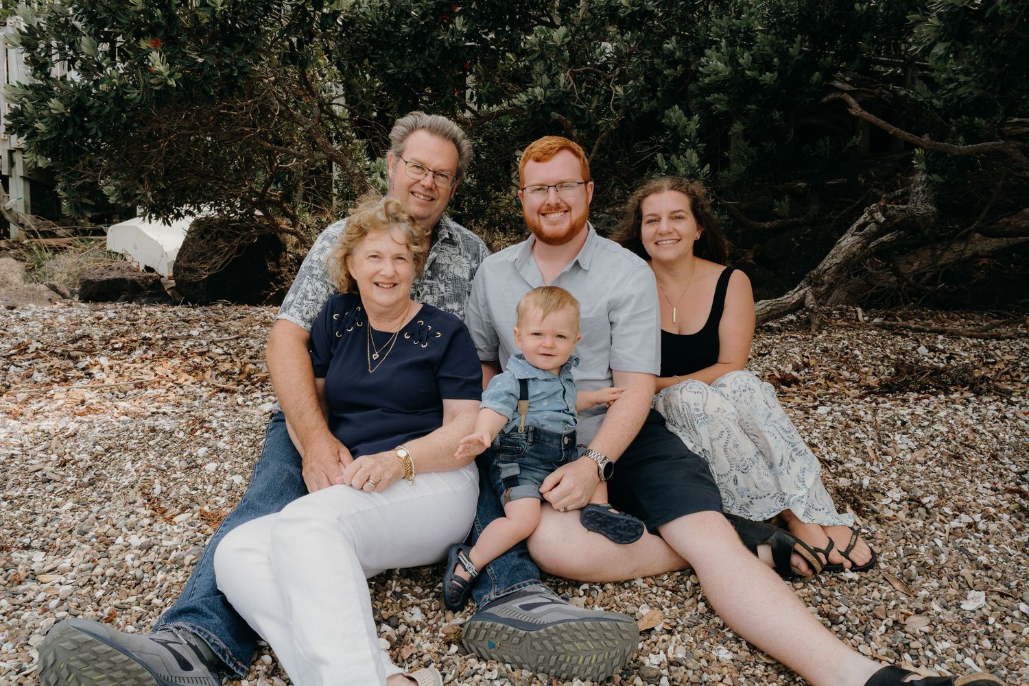 family of five at the beach in posed position looking at the camera