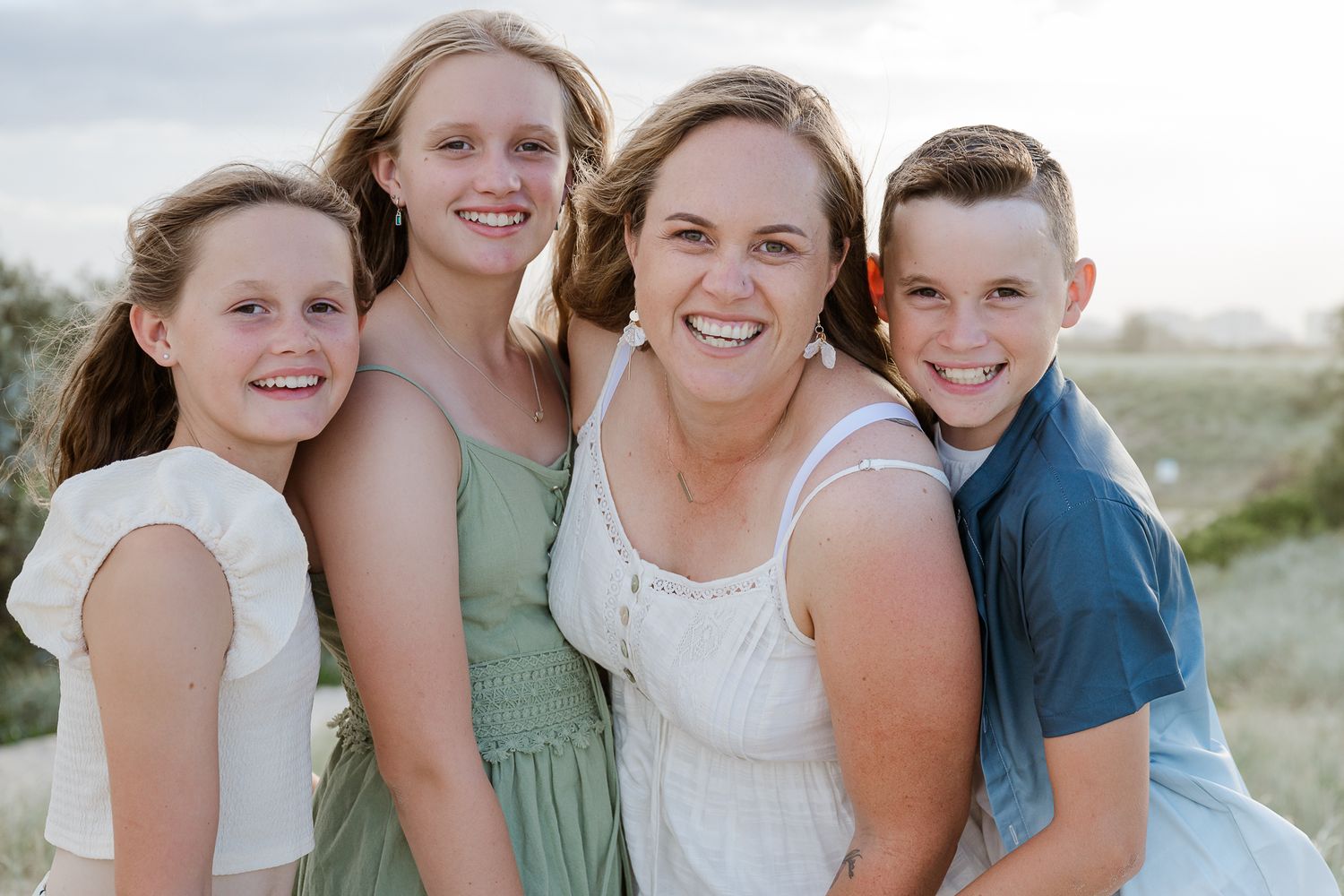 Happy beach portrait of group in casual summer clothing.