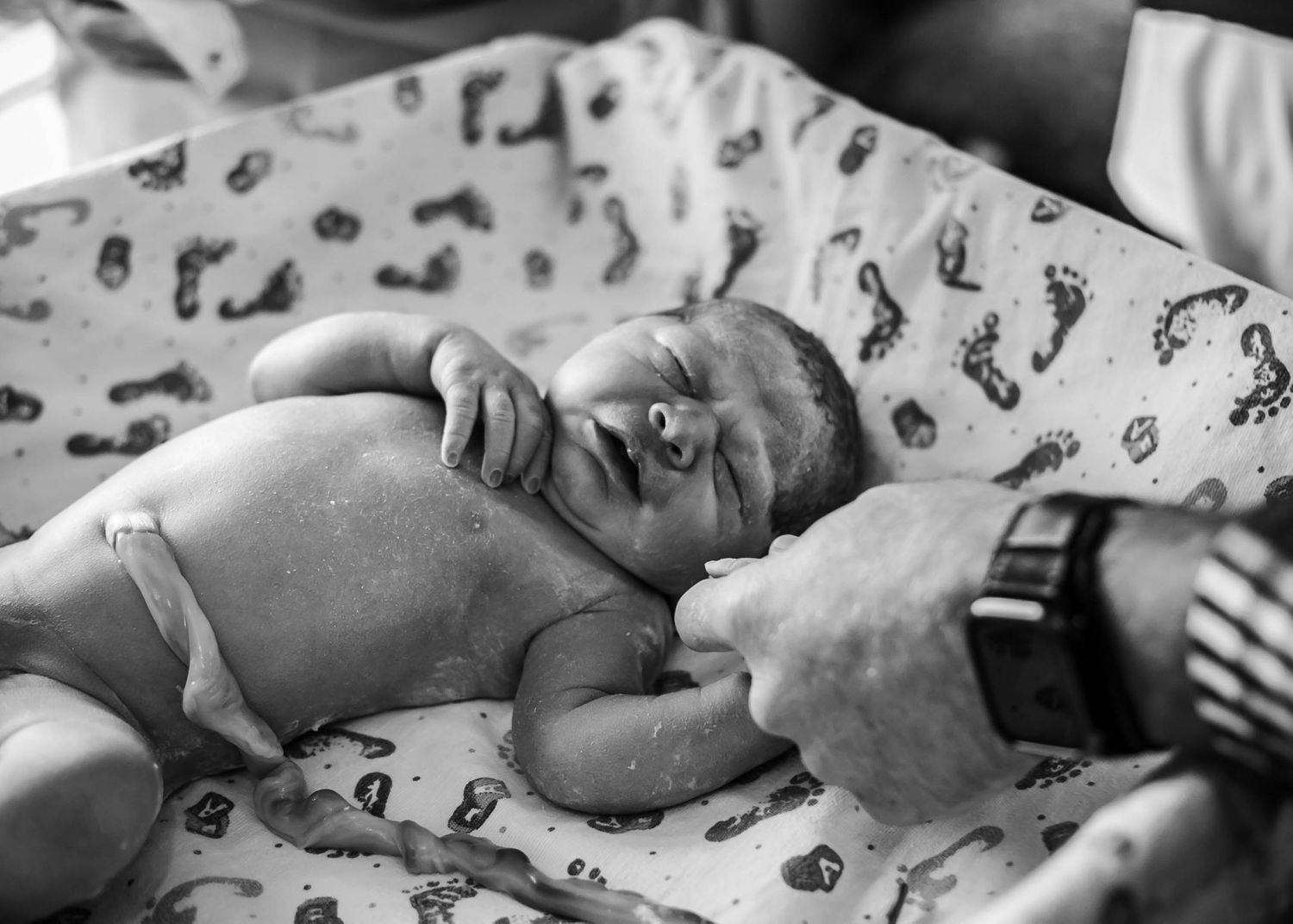 Dad holding newborn son's hand just after birth at UnityPoint Health in Sioux City, IA.