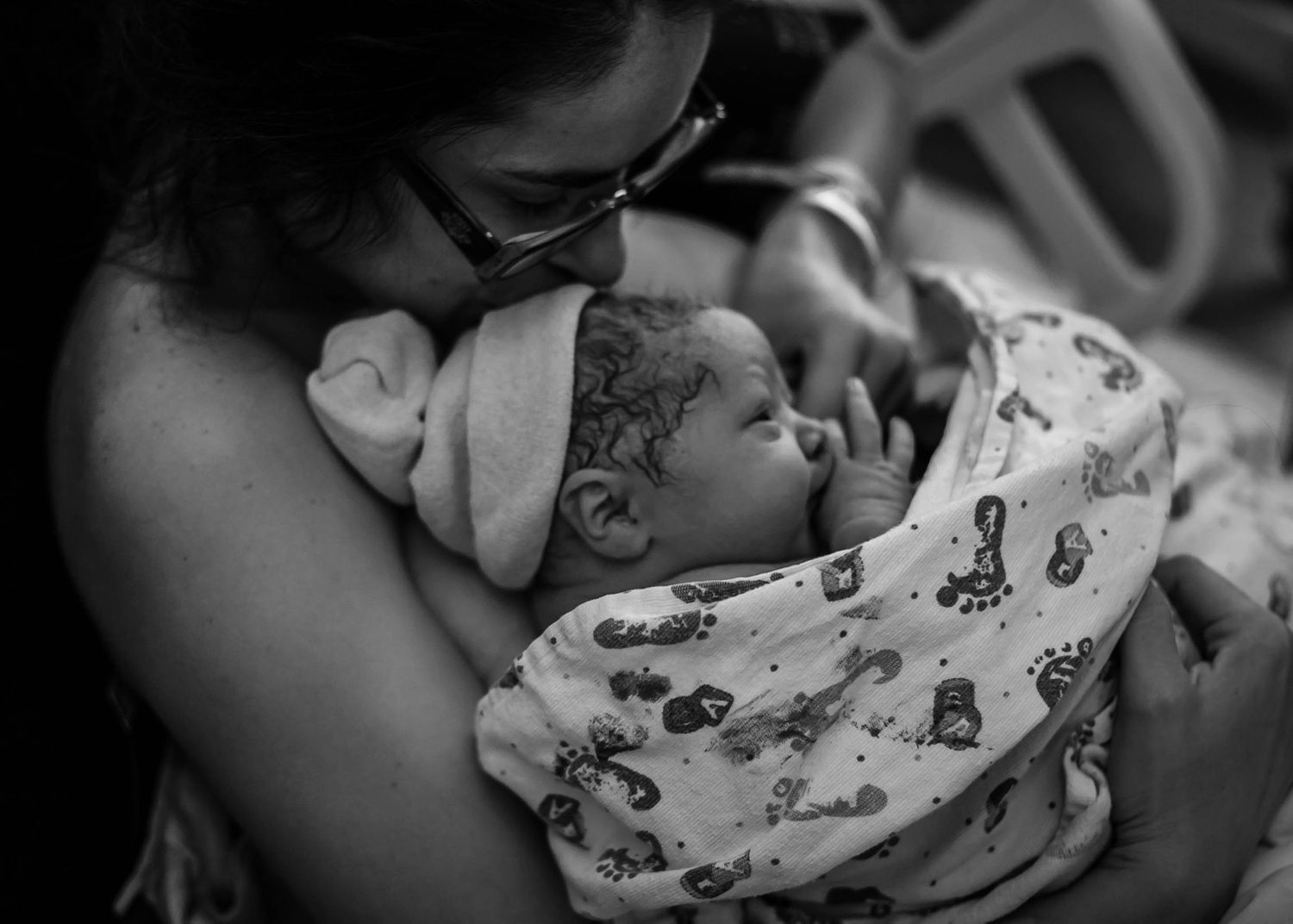 Mom snuggling her brand new baby for some skin to skin bonding just after birth in Sioux City, IA.