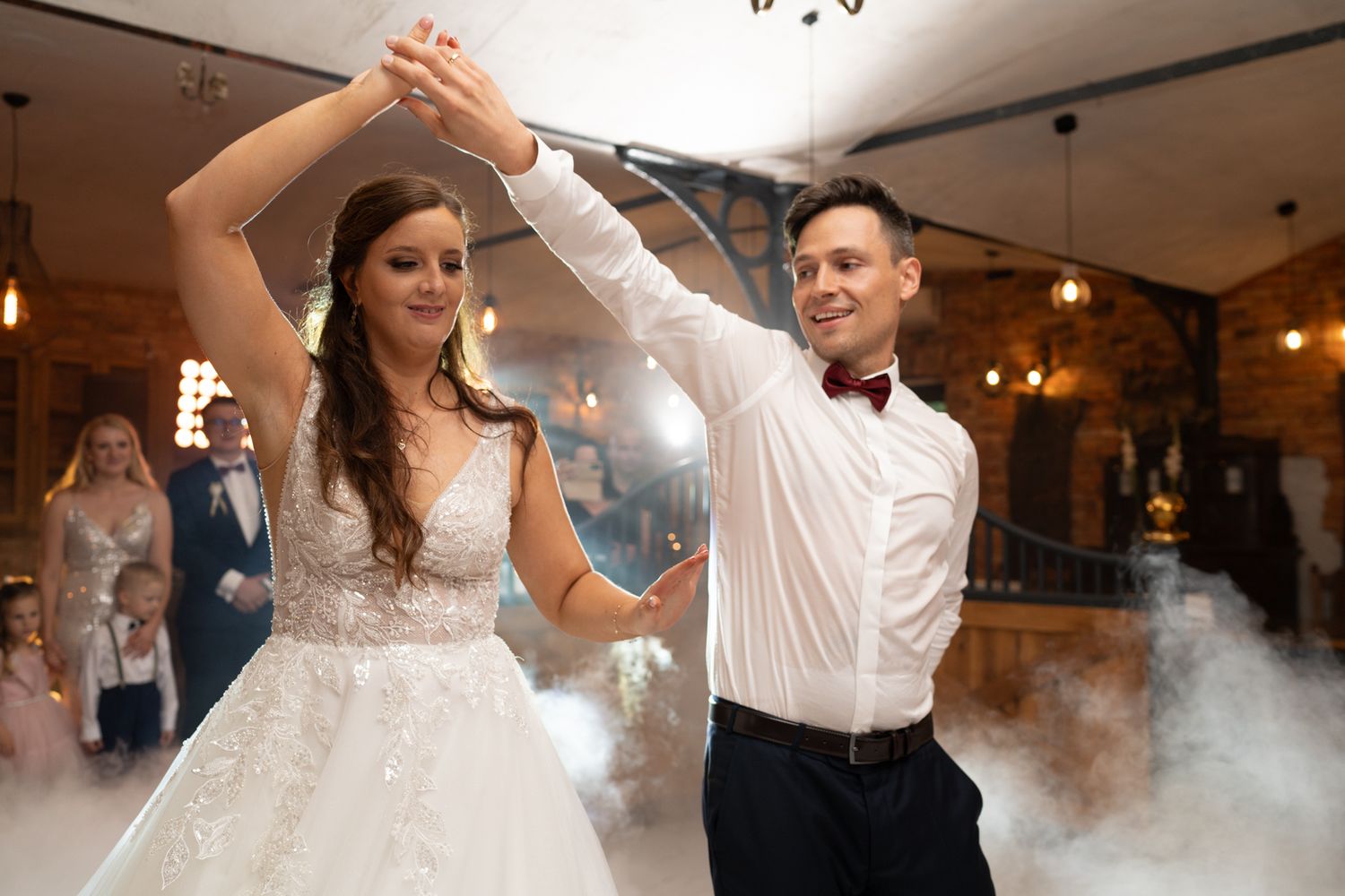 Couple dancing at wedding reception with fog effects creating dreamy atmosphere.