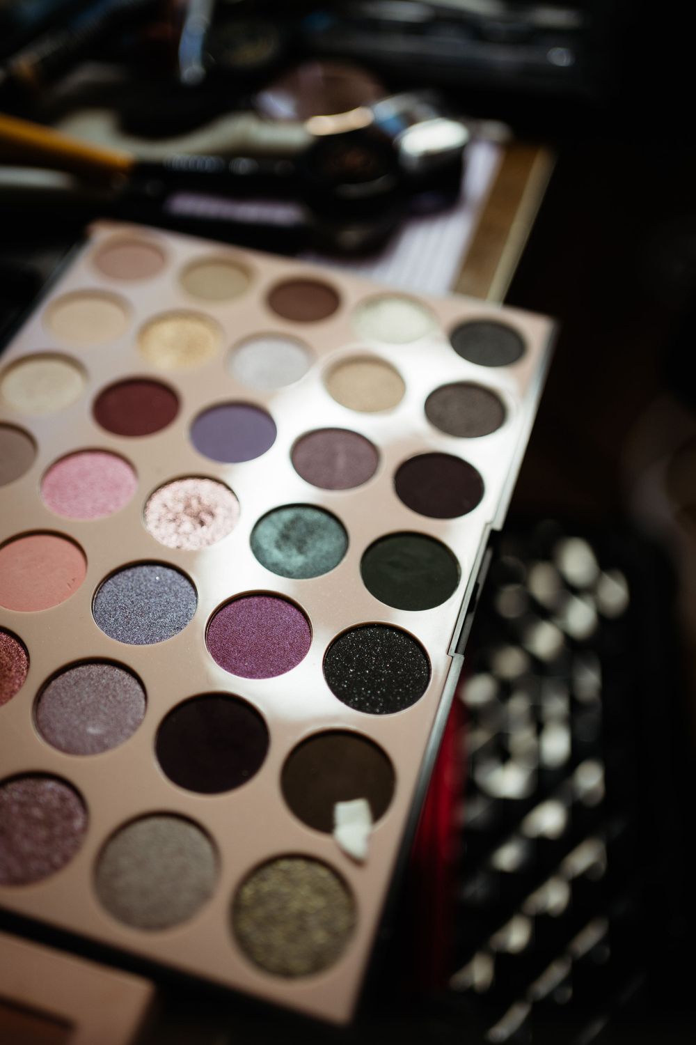 Makeup palette featuring colorful shimmering eyeshadows in various shades.