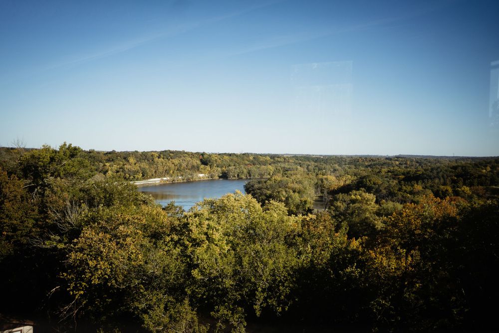 Scenic autumn landscape view of a lake surrounded by trees and rolling hills.