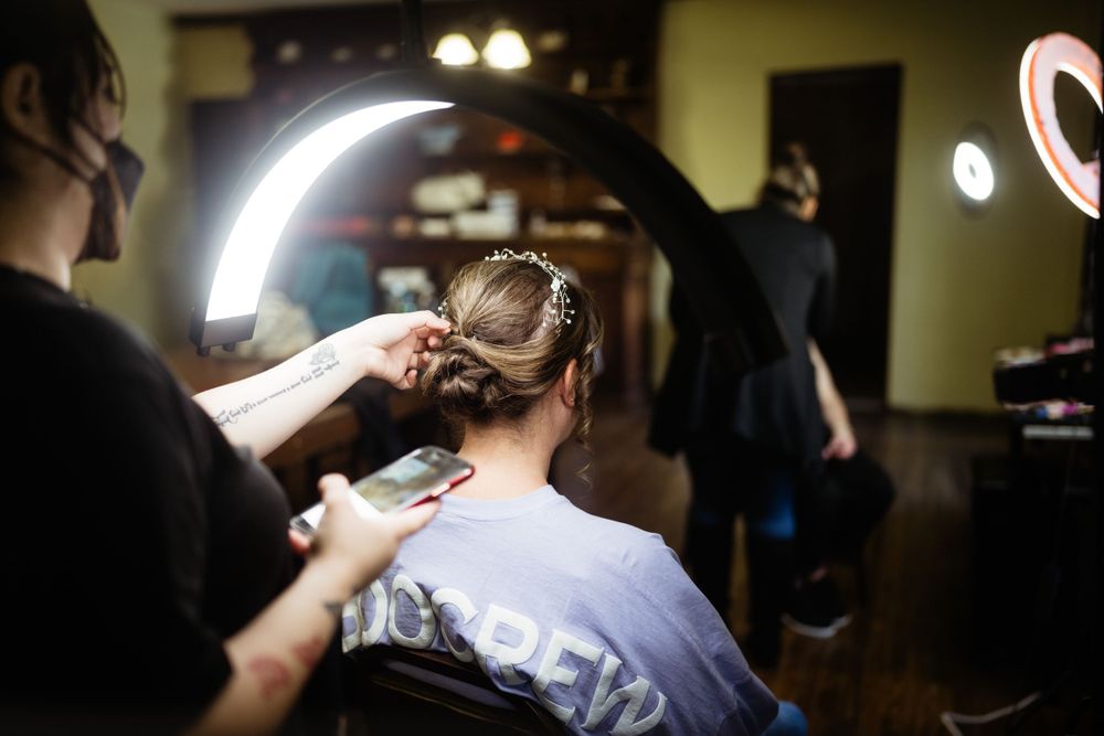 Hair stylist working on an elegant bridal updo in a salon.