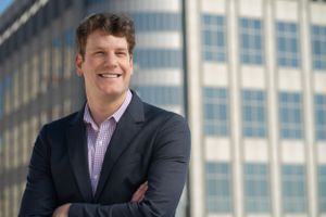 A senior executive, photographed for a corporate headshot, emanating experience and wisdom