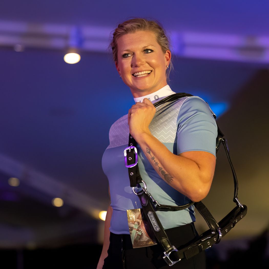 Woman in athletic gear on stage with performance harness equipment.