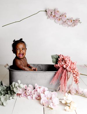 Sweet bath time setup with grey tub surrounded by pink flowers and orchid branches.