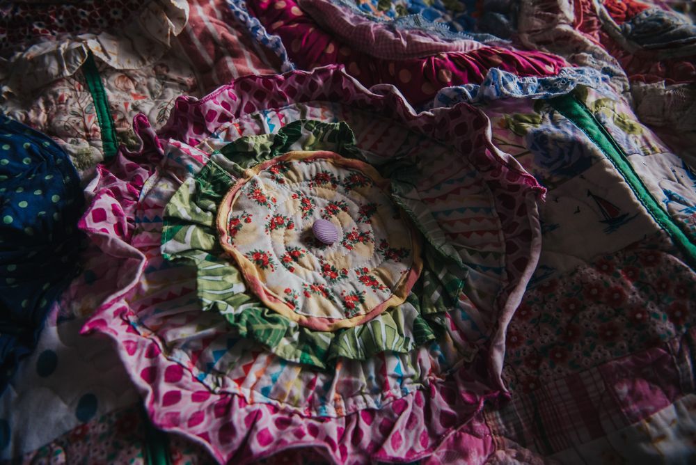 Colourful layered flower applique on a memory quilt.