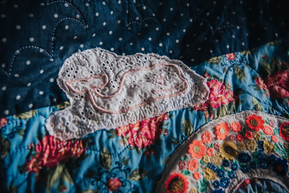 Cloud applique made from a baby dress with a whale on it.