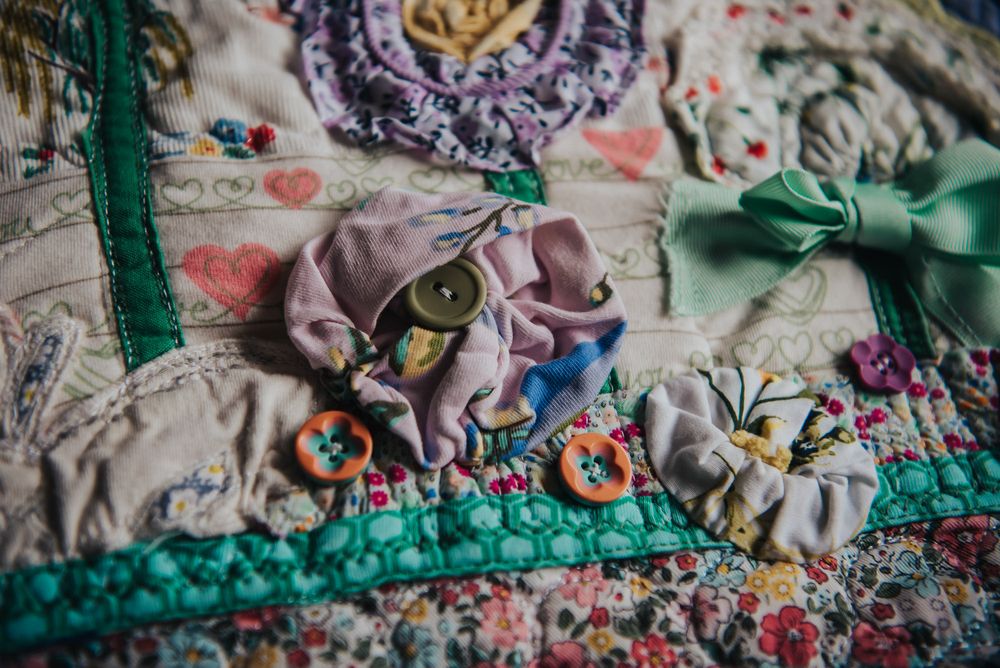 Flower applique made from baby clothes on a memory quilt.