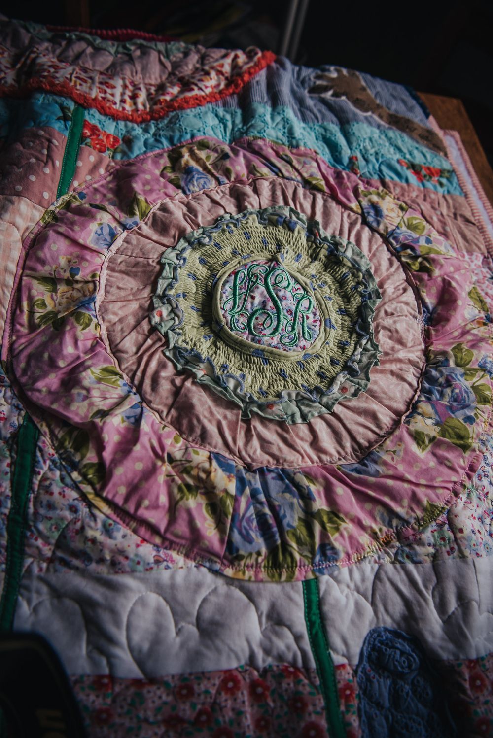 Large flower applique made from baby clothes on a memory quilt.
