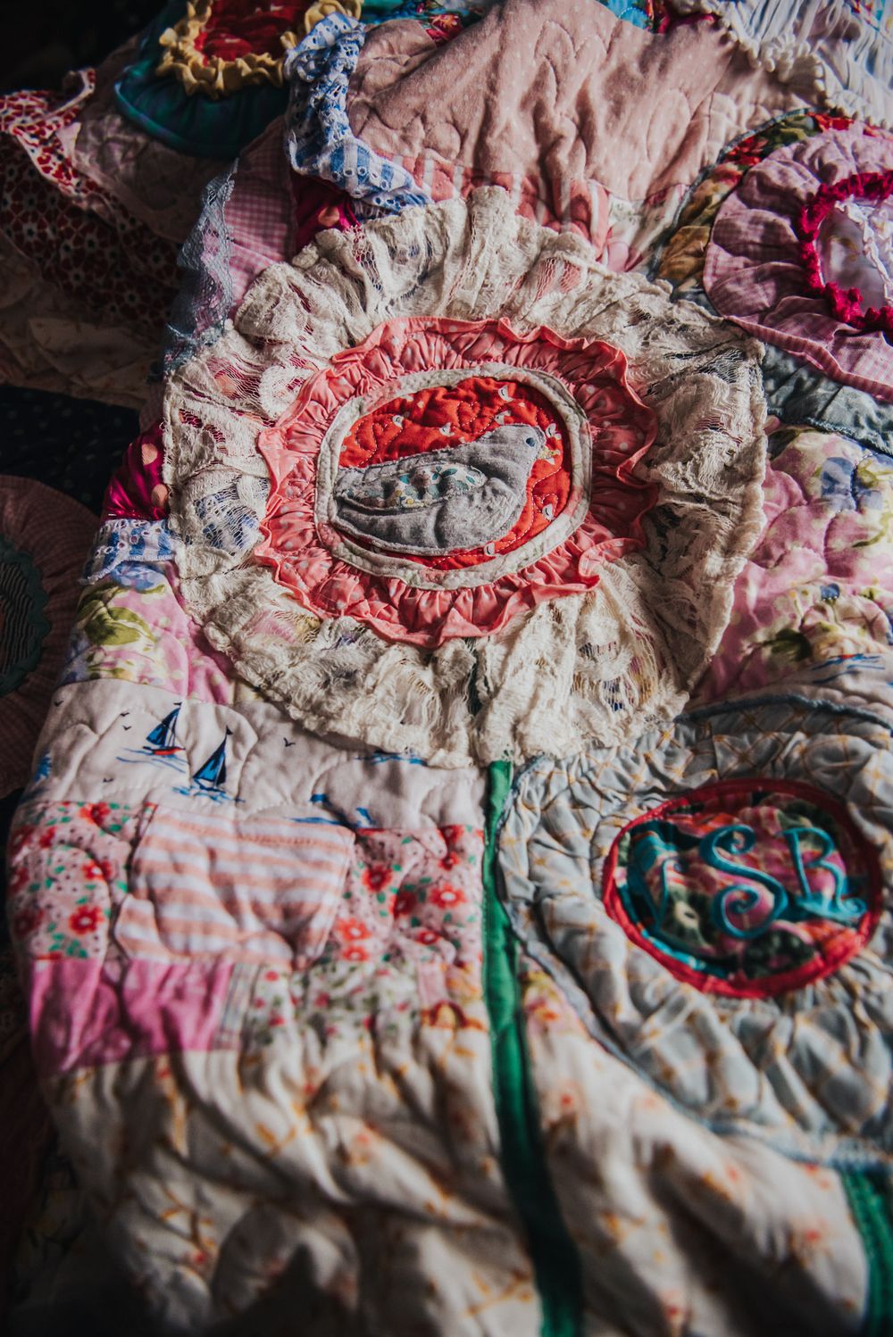 Memory quilt with a large flower applique with a bird in the middle of the flower.