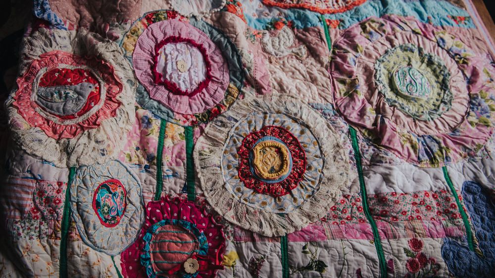 In the Garden memory quilt made with baby clothes and featuring lots of flowers and appliques.
