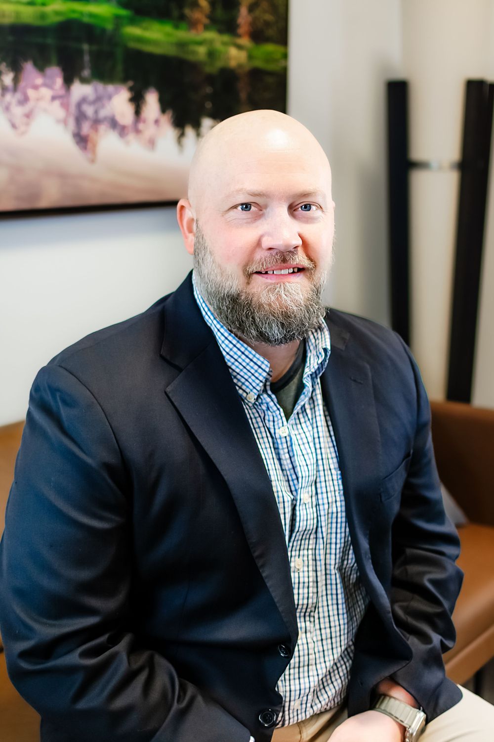 Business portrait of professional in checkered shirt and dark blazer.