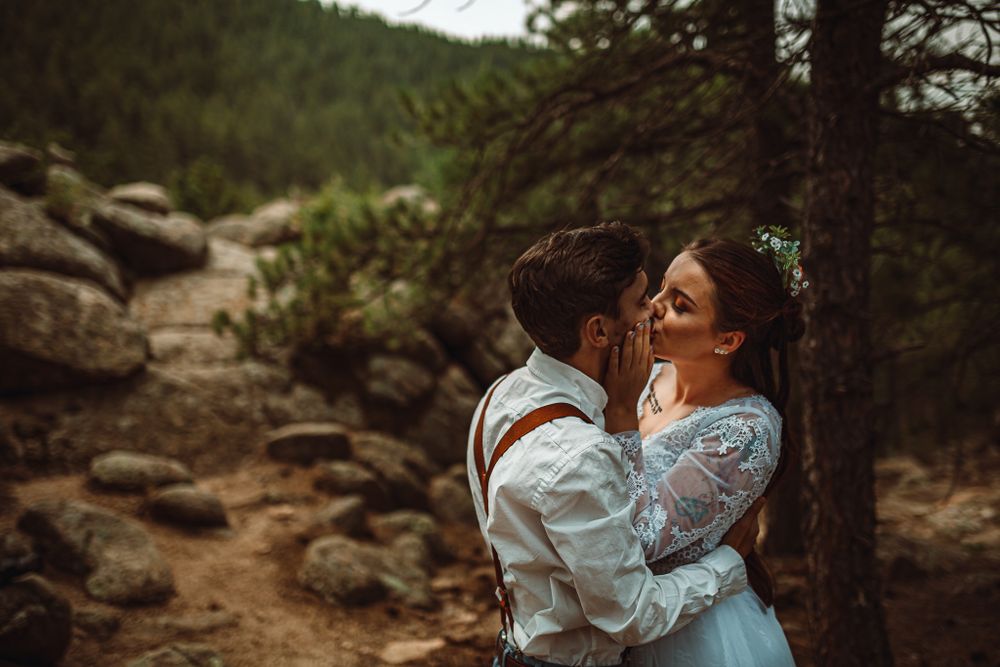 Intimate mountain wedding moment between couple in vintage-inspired attire.