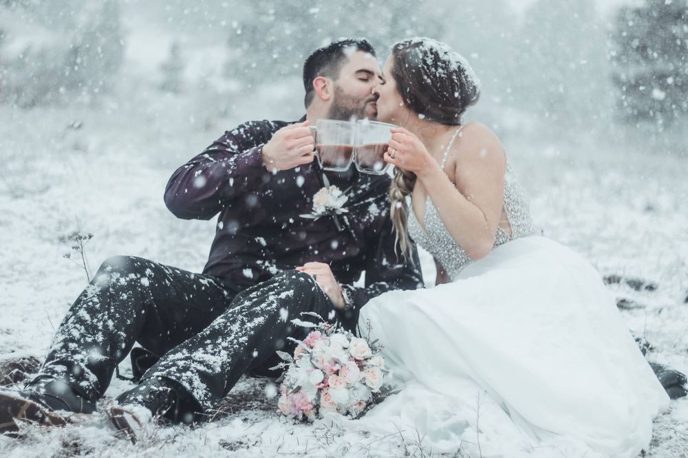 Newlyweds sharing an intimate moment in the snow with bride in white dress.