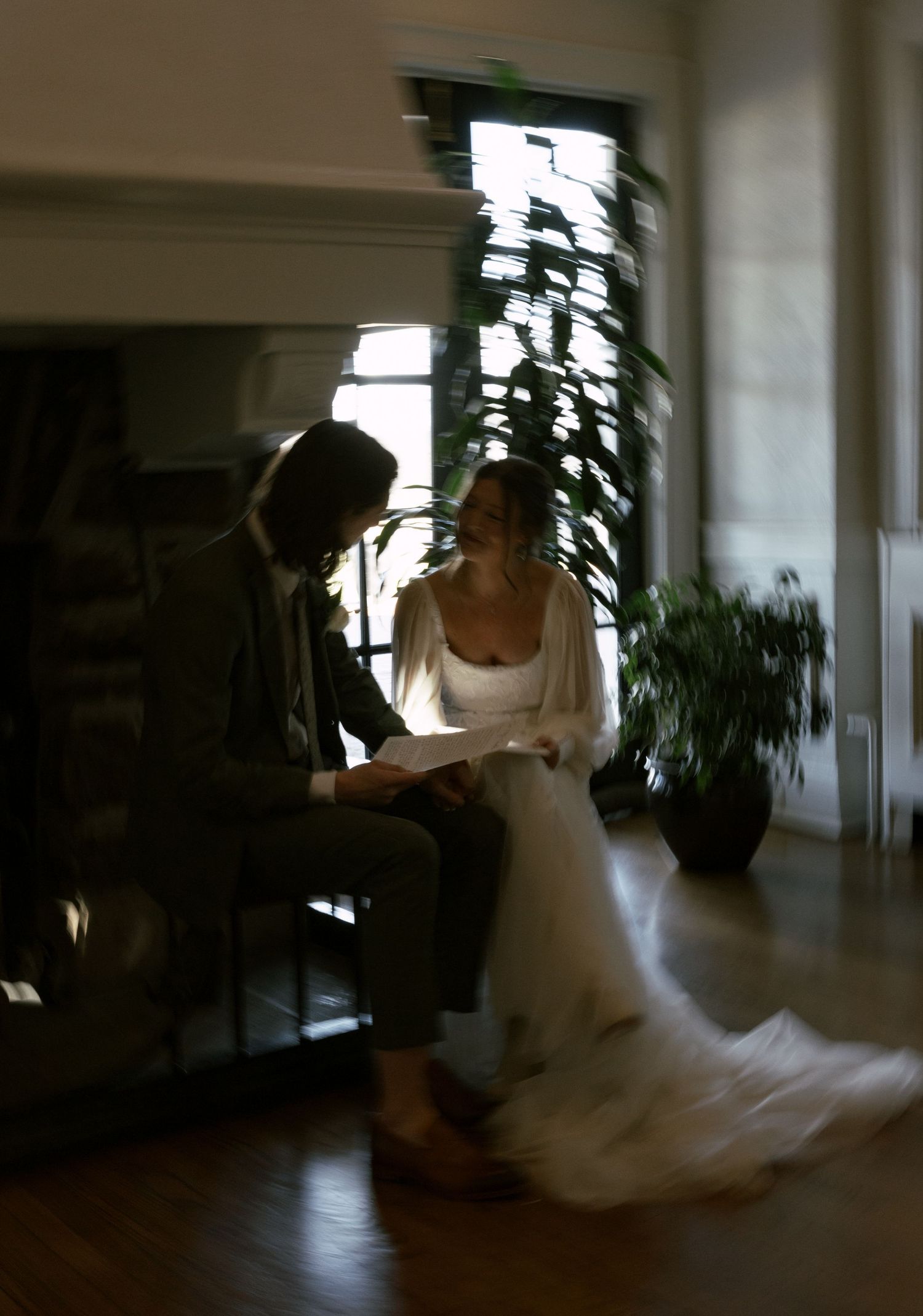 A sequence of dance movements in a dimly lit room with flowing white fabric creating elegant motion.