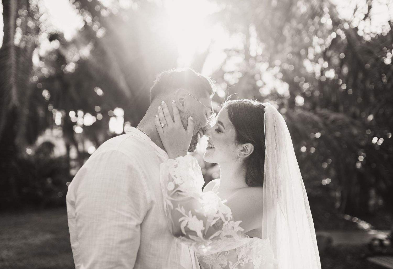Tropical wedding bride and groom with lush palm trees black and white photo