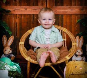 Rustic Easter photography set with wooden chair, decorative bunnies, and spring flowers.