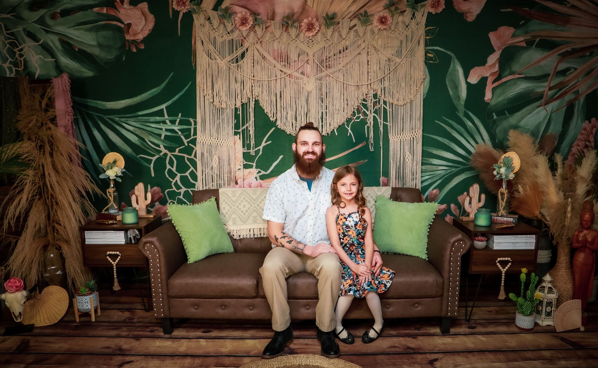 A cozy scene with a brown leather couch, macrame backdrop, and tropical decor in a bohemian-styled photo setting.