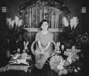 Easter-themed photo setup with bunny decorations and rustic wooden backdrop.