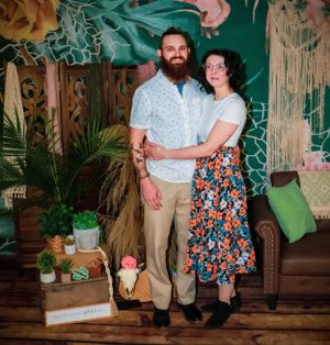 A studio photography session featuring floral patterns and earth-toned decor elements.
