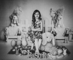 Black and white Easter-themed photo with stuffed bunnies and decorative elements.
