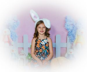 Spring photo session setup with floral decorations and pastel pink background.