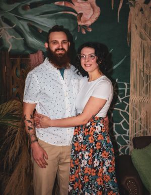 A portrait session featuring coordinated outfits against a bohemian-styled backdrop.