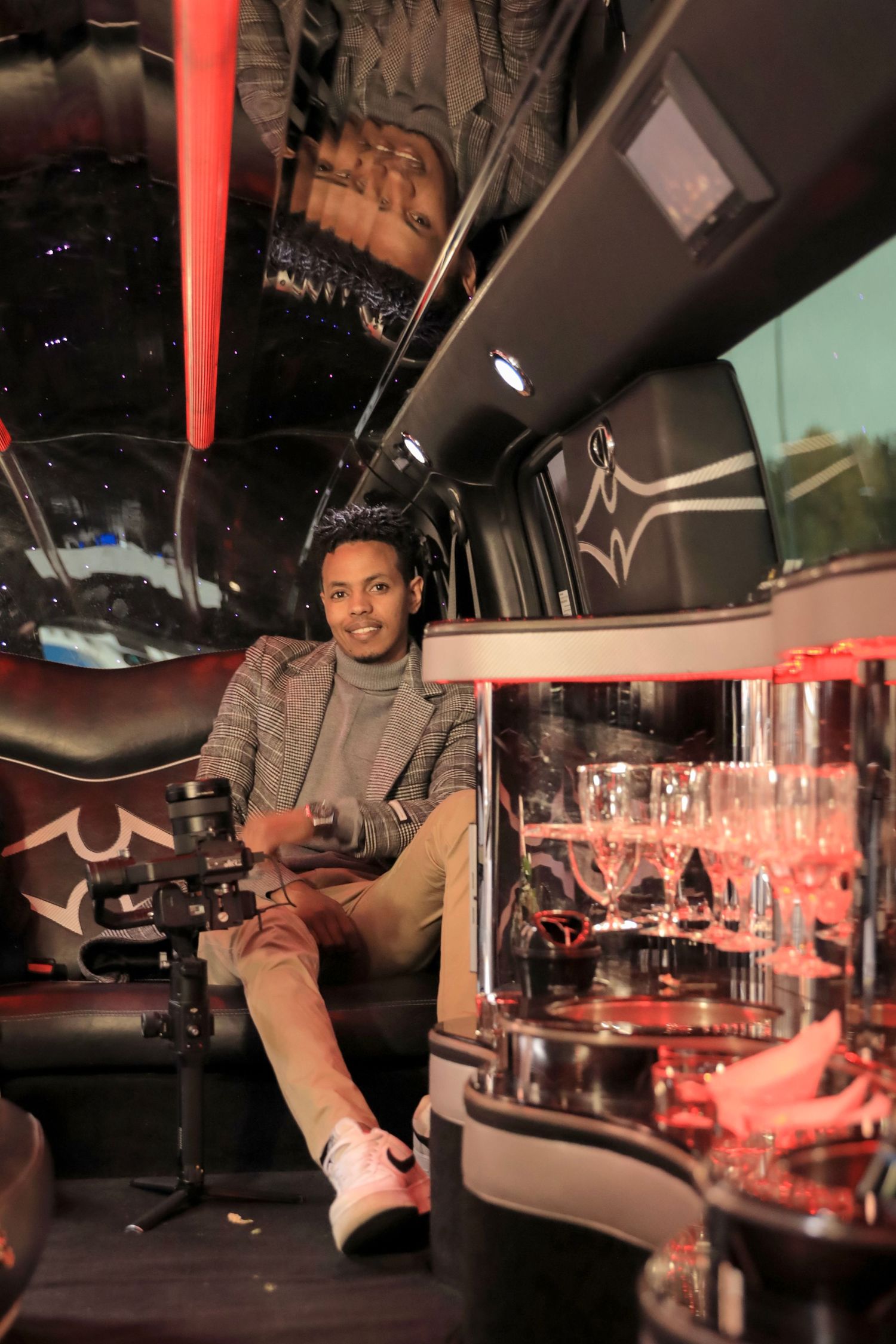 Stylish interior of luxury vehicle with red accent lighting and glass display shelving.
