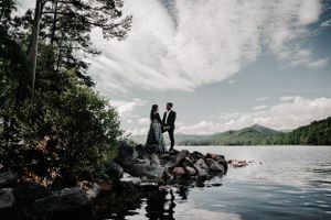 Romantic couple photoshoot by scenic lakeside with mountain views.