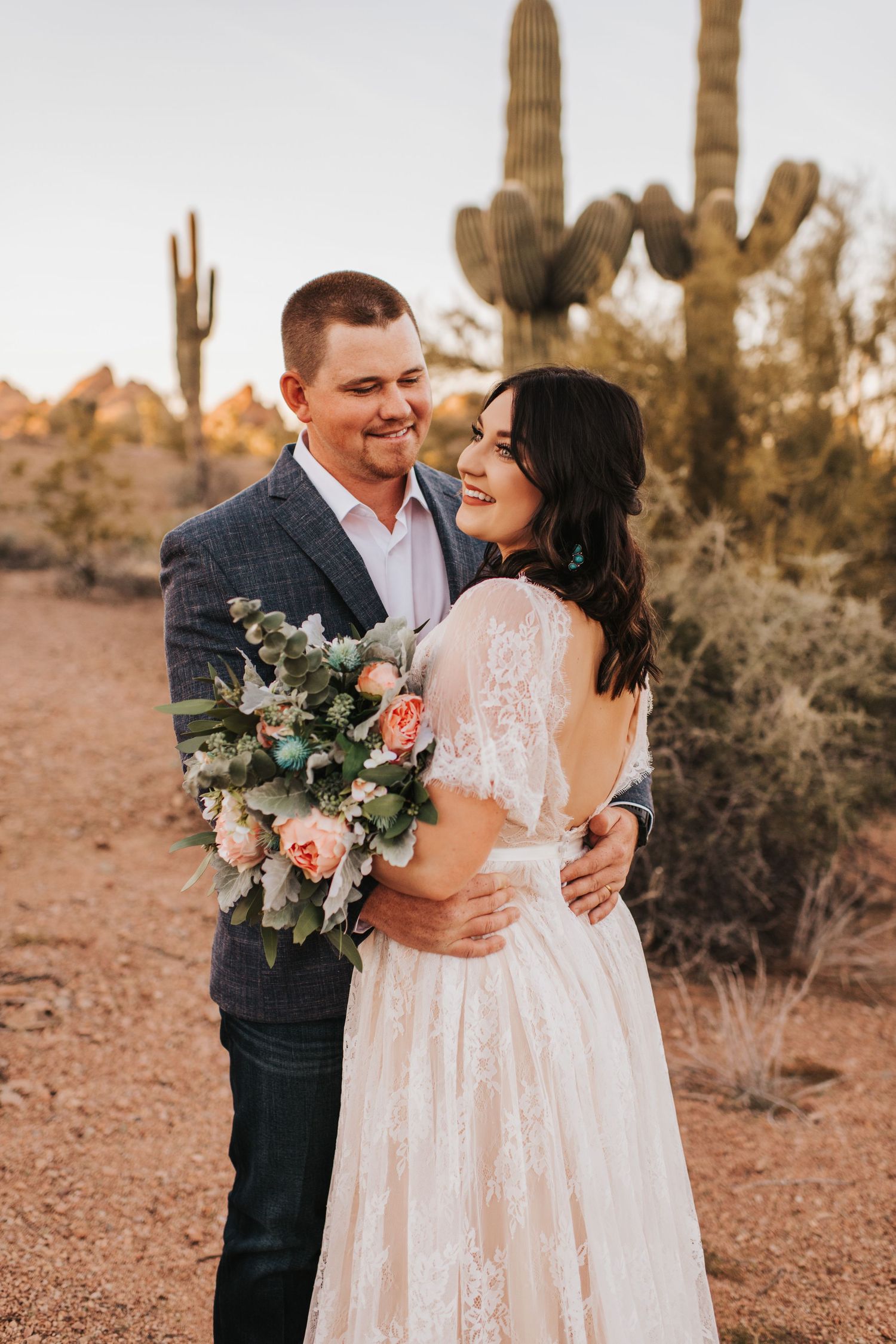 Bride and groom with a beautiful bouquet in a desert setting