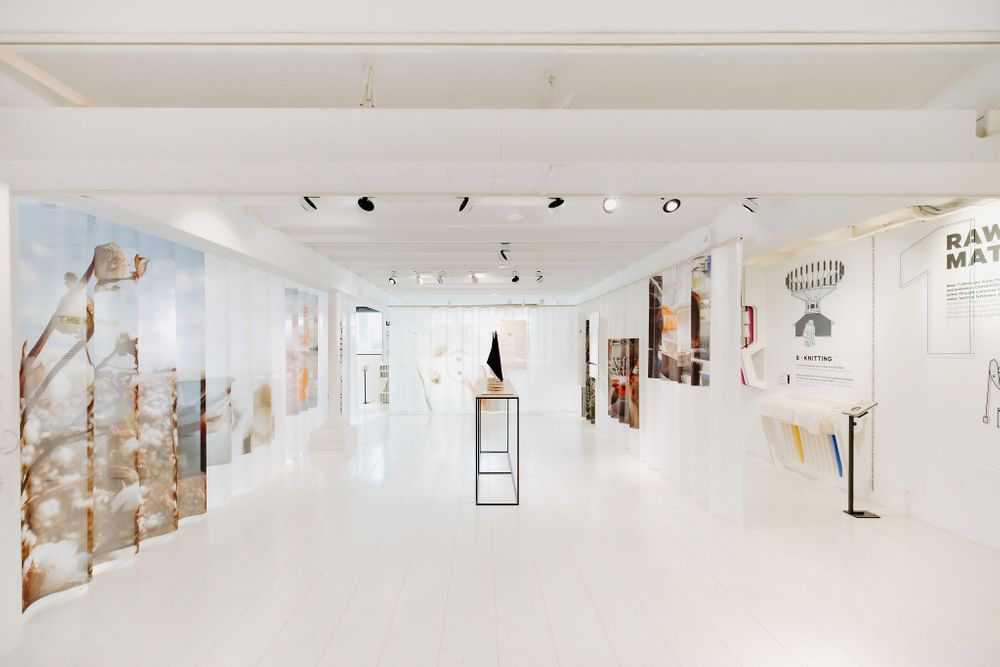 Modern art gallery interior with white walls displaying various artworks and minimalist decor.