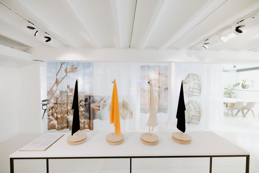 Modern gallery display featuring abstract sculptures in black and yellow on white pedestals.