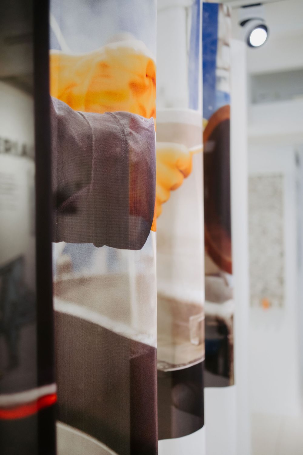 Abstract art installation with orange and brown vertical panels in a gallery setting.