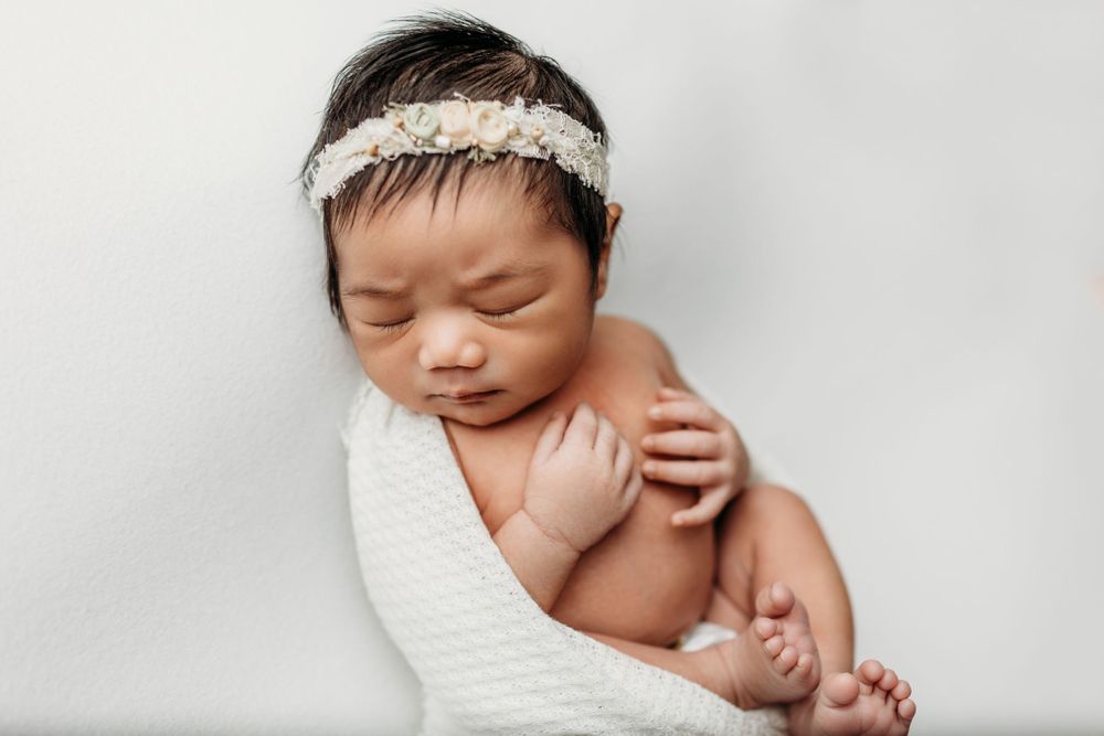 Black and white portrait of sleeping baby with delicate headband.
