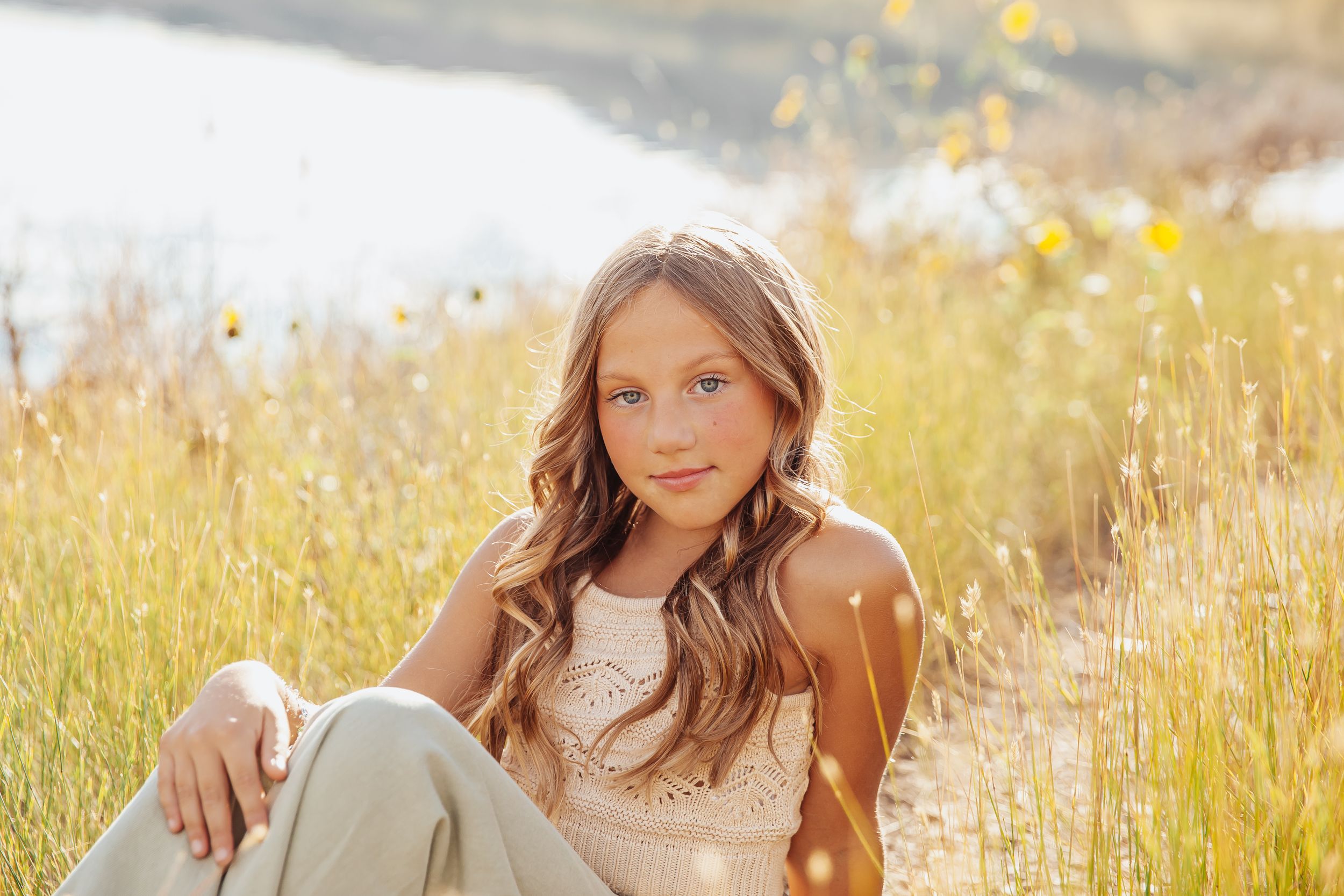 Portrait session in a sunlit meadow with golden grass and natural lighting.
