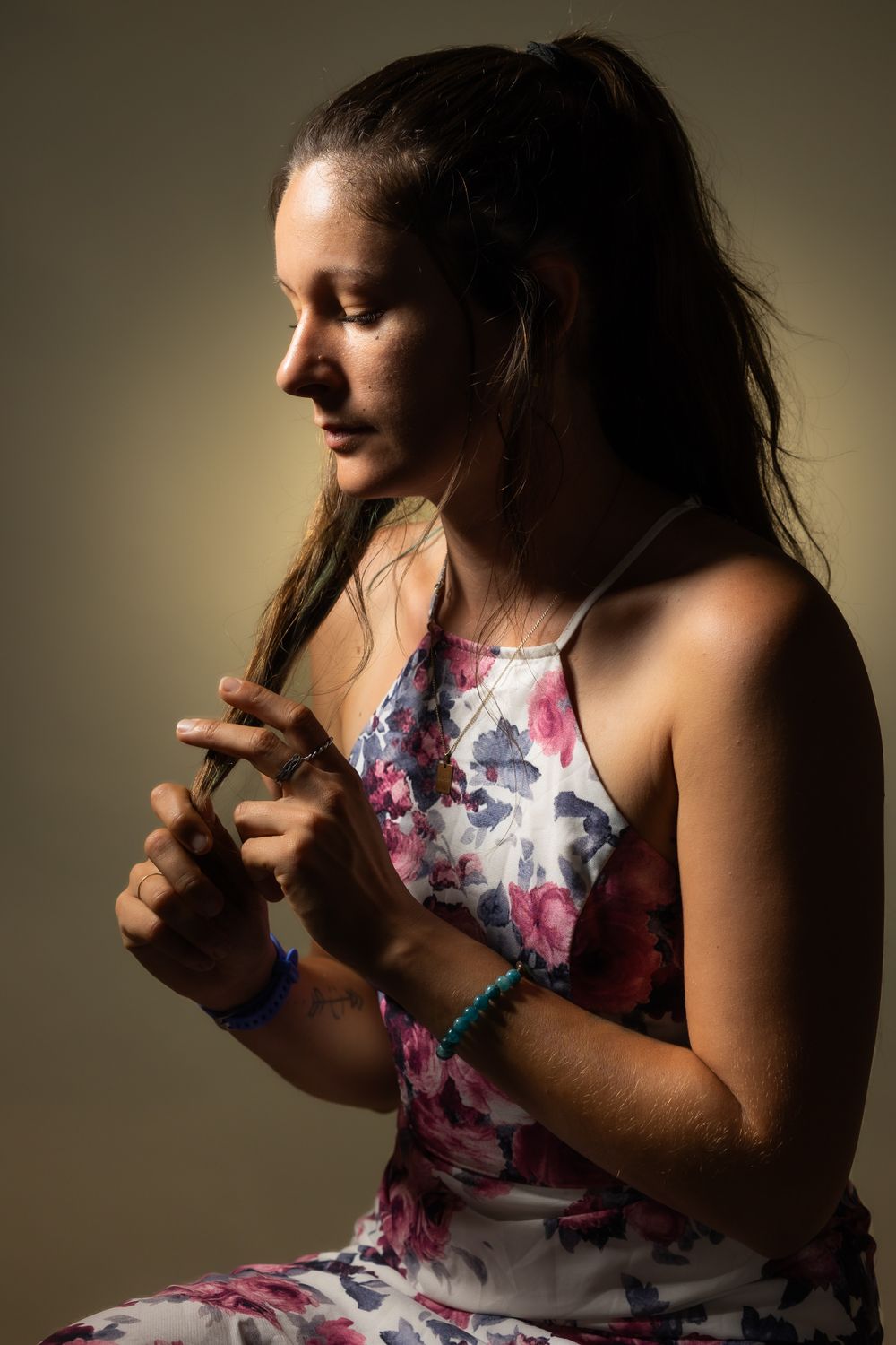 Person in floral dress poses expressively in moody lighting creating a dramatic portrait sequence.