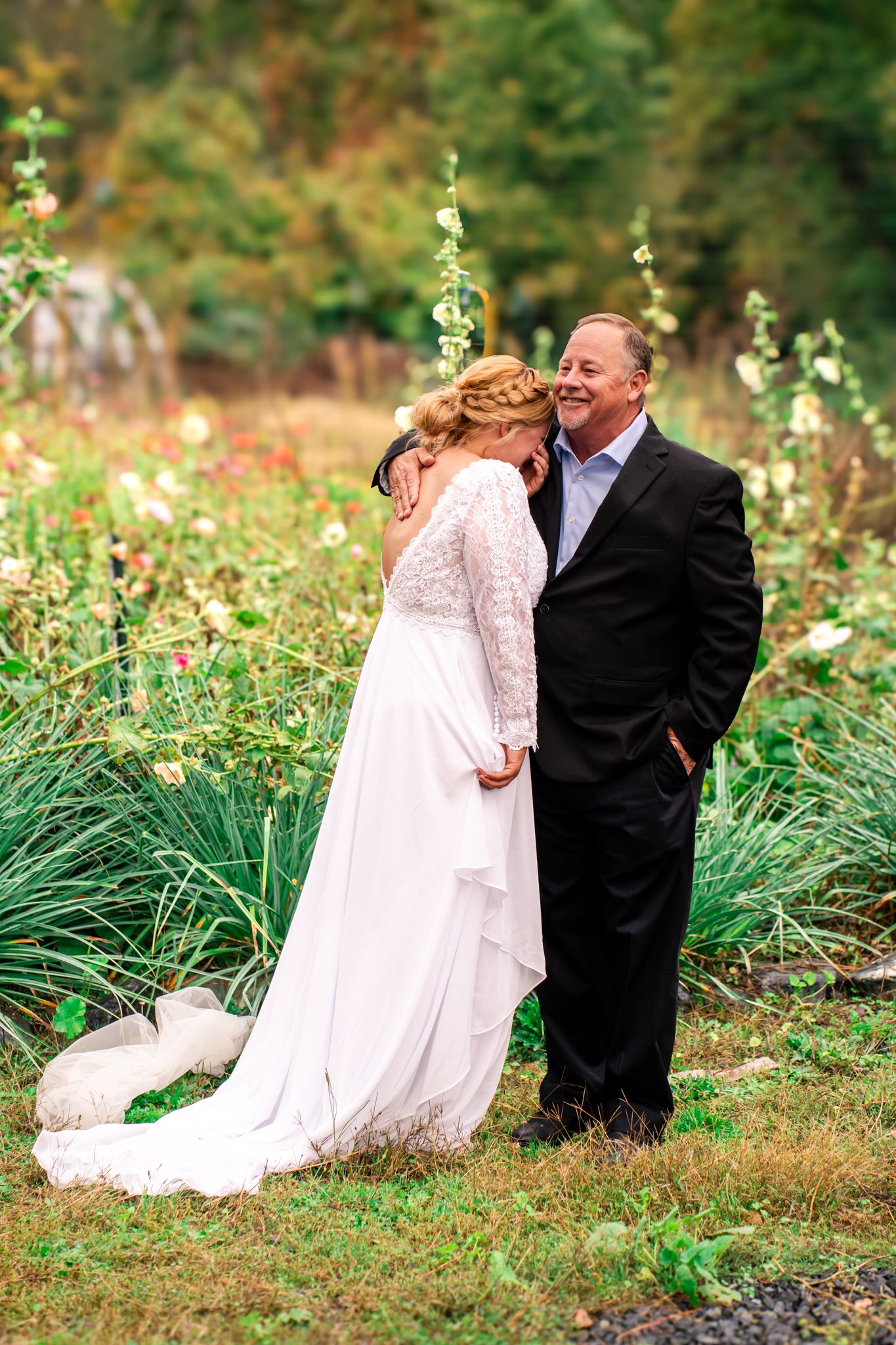 bride starts to cry on dad's shoulder