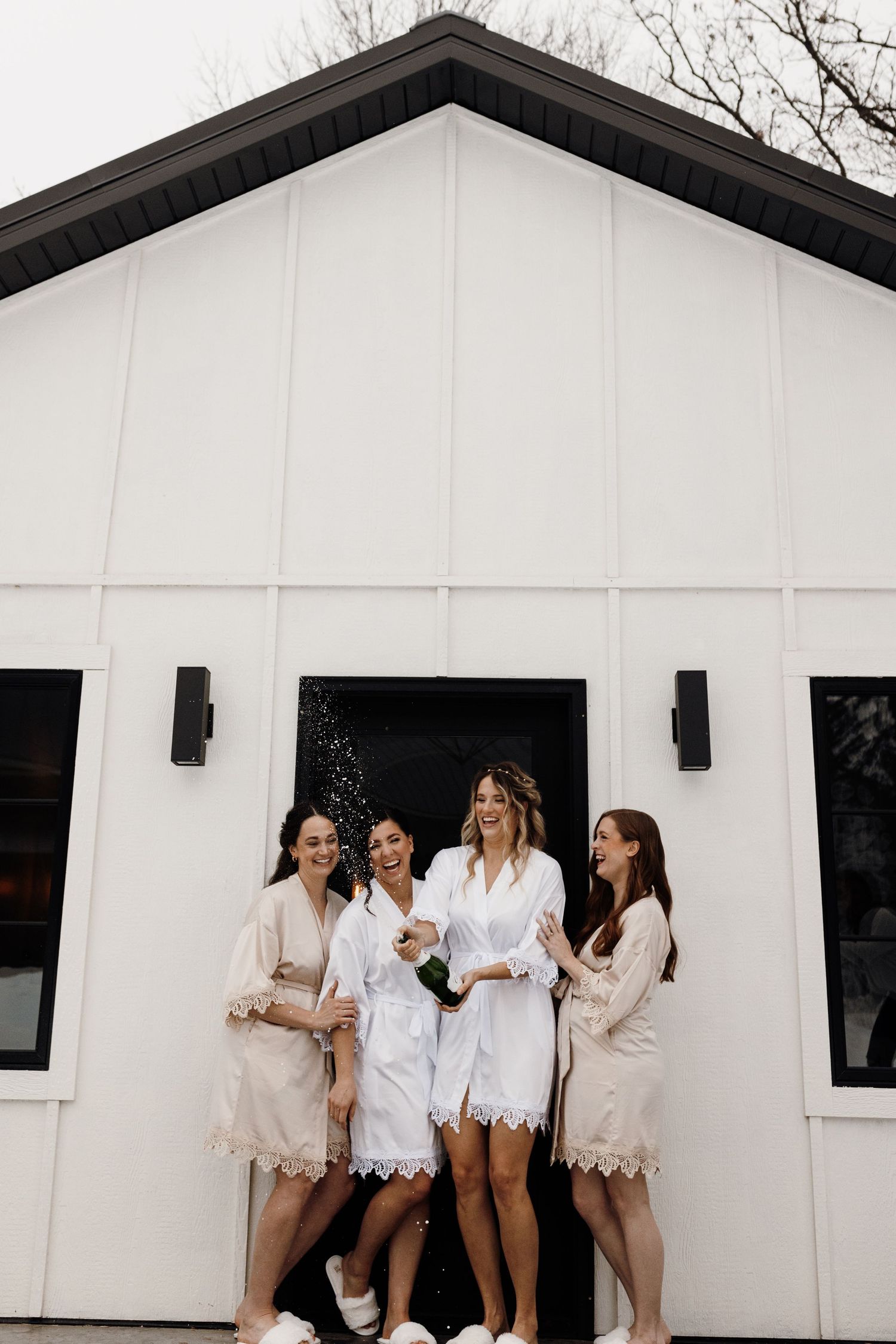 LGBTQ couple and bridesmaids celebrating with champagne outside of the getting ready suite at LaPointe Events