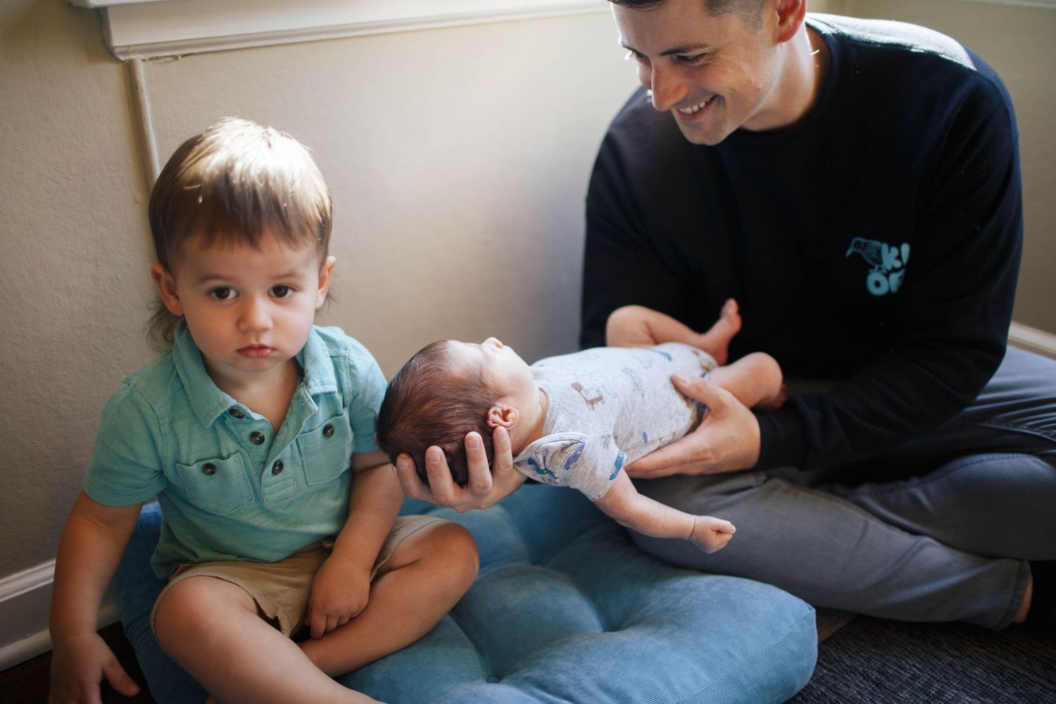everett newborn photography: a newborn dad with his two sons in natural light at home
