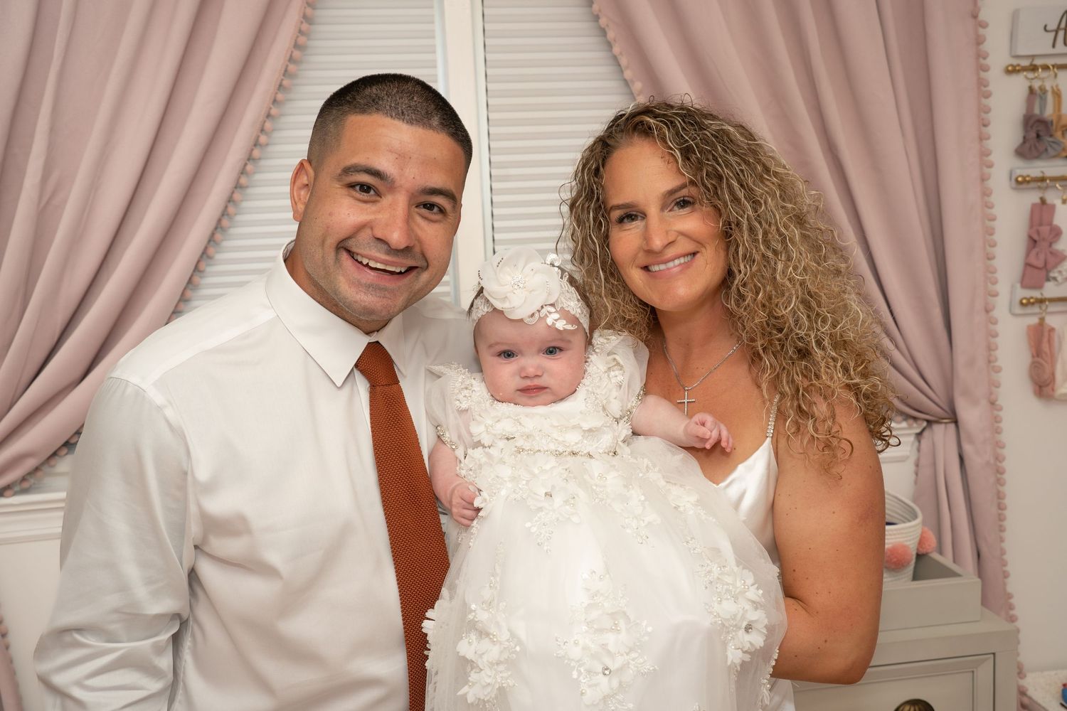 Family members pose together at a baptism celebration event in formal attire.